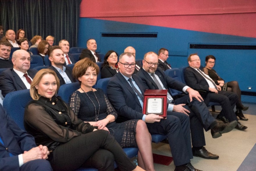 Wicewojewoda siedzi na widowni z innymi uczestnikami uroczystości. 
