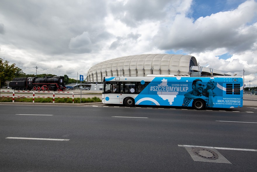 Szczepieniobus na tle stadionu