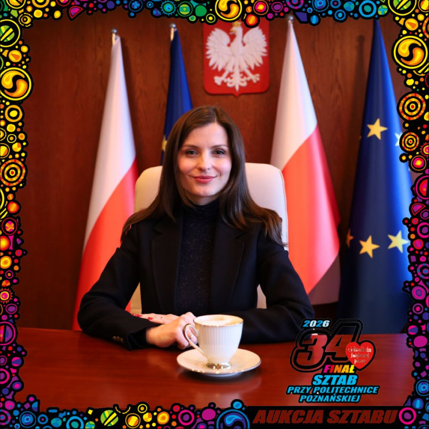 Wojewoda Wielkopolska siedzi przy biurku przy kawie