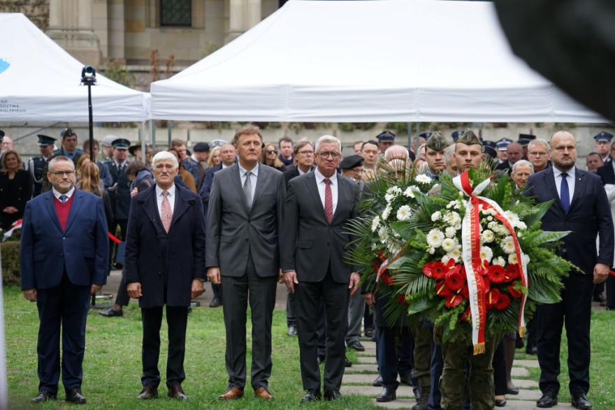 Wspólne składanie wiązanek pod pomnikiem