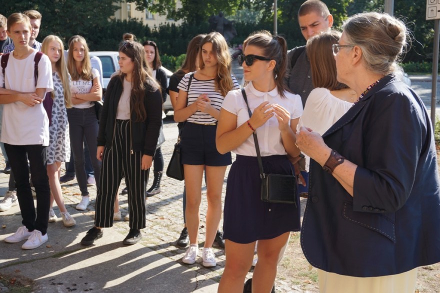 Profesor  Kóčka-Krenz prowadzi wykład dla uczniów przed kościołem Najświętszej Marii Panny na Ostrowie Tumskim w Poznaniu.