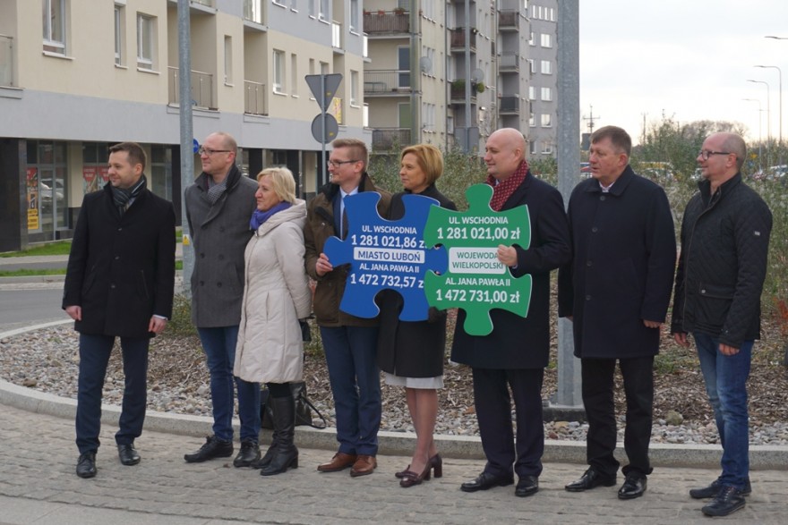 Wojewoda i uczestnicy stoją na rondzie podczas otwarcia drogi.