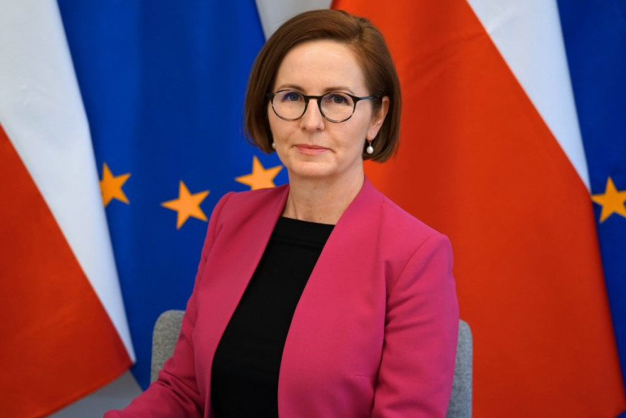 Nowa Dyrektorka Wydziału Prawnego Wielkopolskiego Urzędu Wojewódzkiego w Poznaniu - Małgorzata Drygas na tle flag Polski oraz Unii Europejskiej