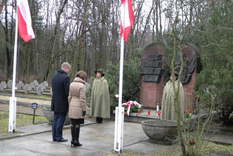 Dyrektor generalny WUW Jacek Woźniak składa kwiaty przed pomnikiem.