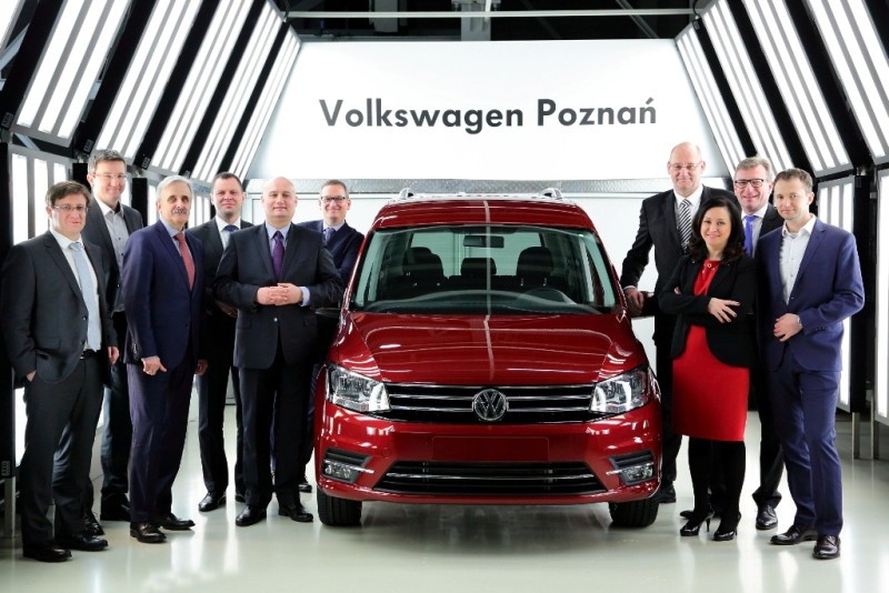 Zdjęcie grupowe wojewody wraz z przedstawicielami firmy Volkswagen przy wyprodukowanym tam samochodzie.