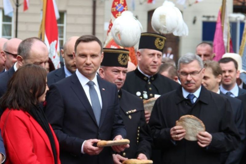 Prezydent dzieli się z pielgrzymami i mieszkańcami Kalisza chlebem.  